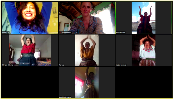 Screenshot of a zoom video call, with 8 people in their separate boxes, each holding their hands above their head and smiling.