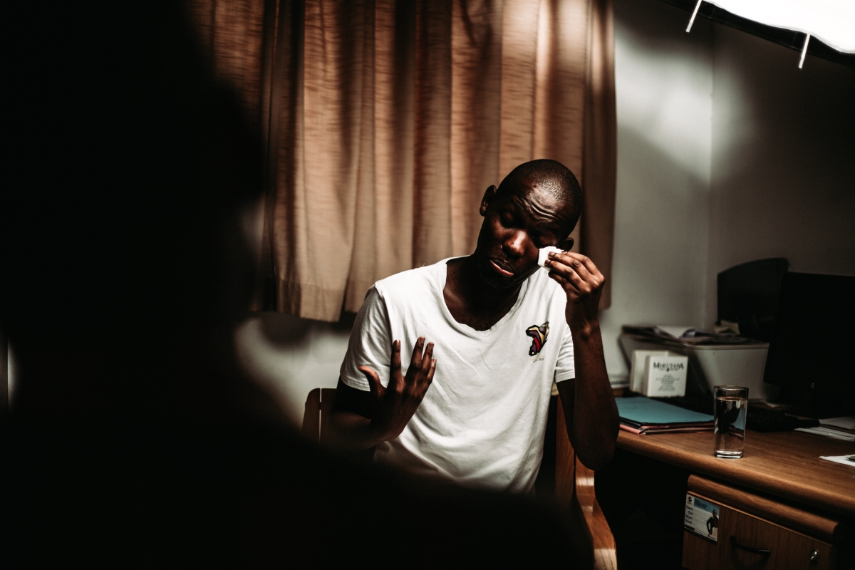 A person wiping tears while in a therapy session